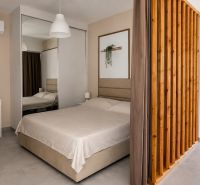 Studio apartment with a bed, mirrored wardrobe, desk, and access to a balcony.