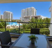 The balcony of a studio apartment in Bogazi with a view of the pool and apartment buildings.