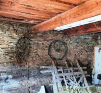 Stone wall in a space with a wooden beam and stored items. Real estate - housing.