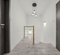 A hallway in a family house with a railing and a floor with a wooden decor.