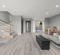 Living room in a family house with a wooden decor floor and a staircase.