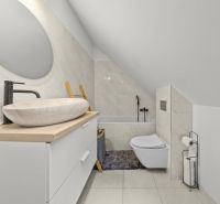 Bathroom with a sink, bathtub, mirror, and tiles in a family house.
