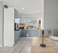 A kitchen in a family house with a dining table and a window, floor with wooden decor.