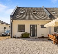 A family house on Strieborná Street in Hurbanovo with a landscaped outdoor seating area and a parked car.