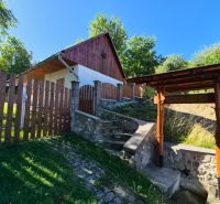 A family house in Mikušovce with a wooden fence and a stone staircase.