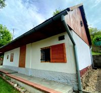 A family house in Mikušovce with a roof covering, wooden shutters, and a well-maintained garden.