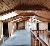The attic of a family house with wooden paneling and skylights.