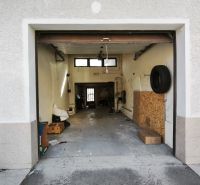 An open garage in a family house on Ľ. Štúra in Veľký Krtíš with several items inside.