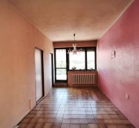 A hallway with ceramic tiles, pink walls, a window, and a chandelier in a family house.