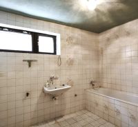 Bathroom with tiles, sink, and bathtub in a family house.