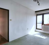 Interior of a family house with a large window, exposed radiator, and subtle decorations.