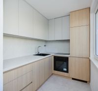 A kitchen unit in a 3-room apartment with wooden elements and light cabinets.