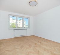 A room in a 3-room apartment with white walls and a floor with a wood decor.