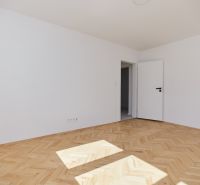 A bright room with white walls and a floor with a wooden decor, a 3-room apartment.