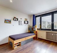 A children's room with a bed and a window with a view; a 4-room apartment with a floor with a wooden decor.
