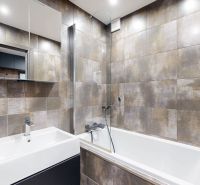 A bathroom with modern tiles and sanitary ware in a 4-room apartment.