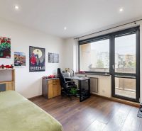 Children's room with large windows, comic posters, and a floor with a wood decor.