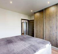 Bedroom in a 4-room apartment with a sliding wardrobe and a wooden decor floor.