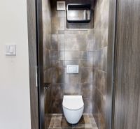 A toilet with dark tiles in a 4-room apartment, elegant room design.