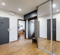 Interior of a 4-room apartment with wood-decor flooring and built-in wardrobes.