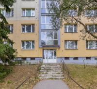 The entrance of the apartment building on Benadova Street in Košice, surrounded by greenery, suitable for a 4-room apartment.