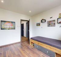 Children's room with a bed, shelves, and a wooden decor floor in a 4-room apartment.