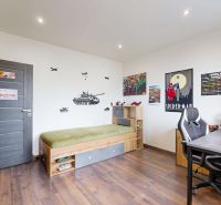 Children's room in a 4-room apartment with a wooden decor floor and decorations on the walls.