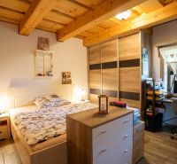 A room in a family house with a bed, a wardrobe, and a desk with a computer.