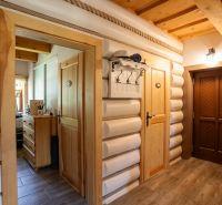 Interior of a family house with wooden walls, a floor with a wooden design, and wooden doors.