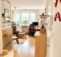 Interior of a 2-room apartment with a wooden decor floor and a work corner.
