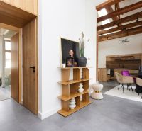 Interior of a 3-room apartment with a shelf, elegant chairs, and a floor with a wood design.