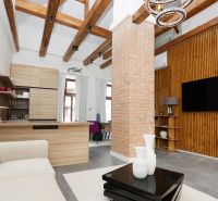 Living room in a 3-room apartment with exposed beams and a brick pillar.