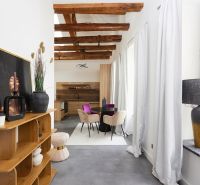 Living space of a 3-room apartment with wooden beams and decorative furniture.