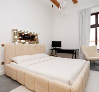 A bright bedroom with a comfortable bed, a desk, and a chair in a three-room apartment.
