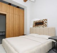 A bedroom in a 3-room apartment with wooden ceiling beams and a spacious bed.