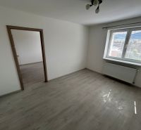A room with a wooden floor decor, white walls, and a large window in a 3-room apartment.