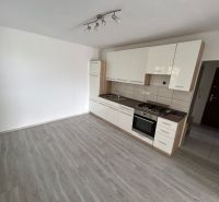 A kitchen in a 3-room apartment with built-in appliances, flooring with a wooden decor.