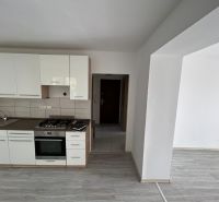 A kitchen unit with a wooden decor in a 3-room apartment, a space with white walls.