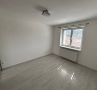 An empty room with wood-patterned flooring and white walls in a 3-room apartment.