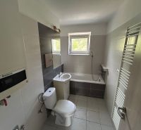 Bathroom in a 3-room apartment with a bathtub, sink, toilet, and ladder radiator.