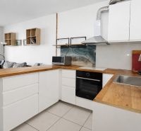 A kitchen with wooden decor and a sofa in a 2-room apartment.