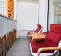 The balcony of a 2-room apartment with two chairs and a table on Jégého Street in Bratislava.