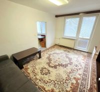 Living room in a 3-room apartment with a patterned carpet and a sofa.