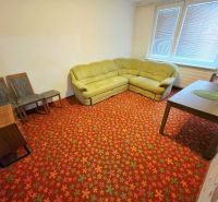 Living room in a 3-room apartment with a floral carpet and a corner sofa.