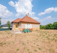 A family house in Nitra with a red roof surrounded by a large yard and greenery.