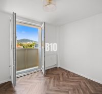 A room in a 3-room apartment with a view and a floor with a wooden decor.
