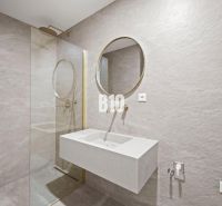 A bathroom with a round mirror and a shower in a 3-room apartment.