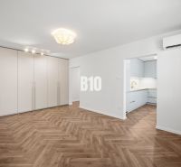 Living room in a 3-room apartment with a wooden decor floor and a built-in wardrobe.