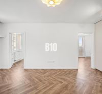 A room in a 3-room apartment with a wooden decor floor and built-in wardrobes.