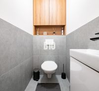 A bathroom in a family house with gray tiles and a simple design.